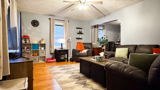 a living room with furniture fireplace and a large window
