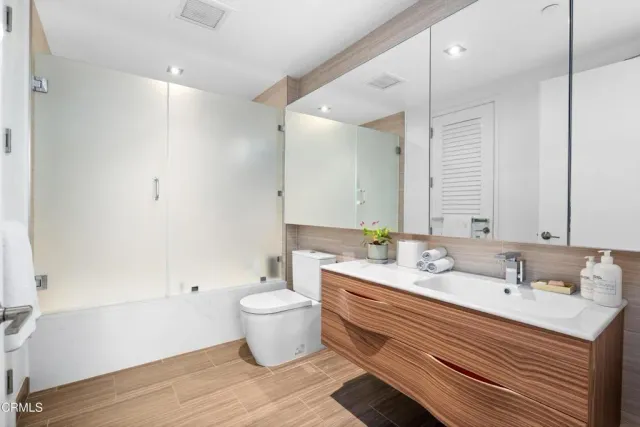 a bathroom with a double vanity sink mirror and toilet