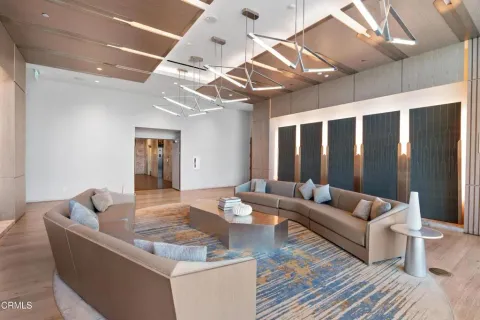 a living room with couches and a dining table with wooden floor