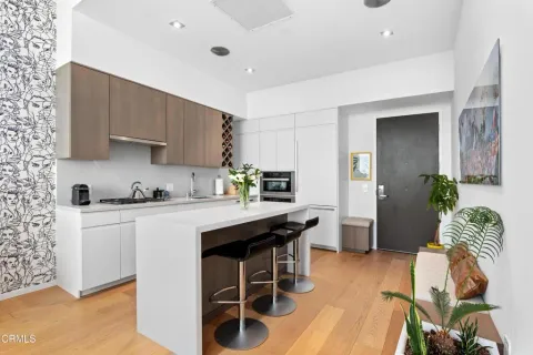 a kitchen with stainless steel appliances granite countertop a white cabinets and wooden floor
