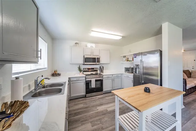 a kitchen with a refrigerator sink and wooden floor