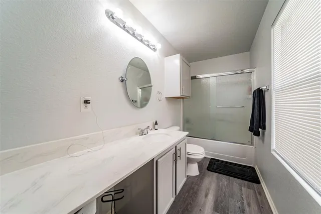 a bathroom with a sink a toilet a mirror and shower