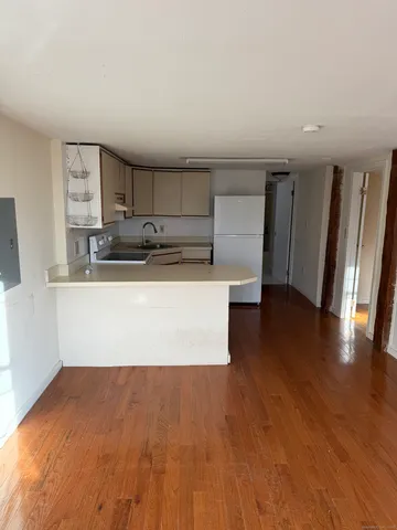 a view of a kitchen with a sink and dishwasher wooden floor