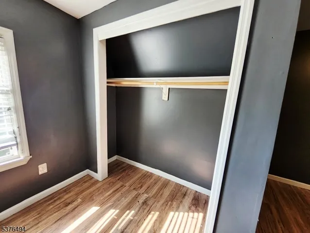 a view of room with window and wooden floor