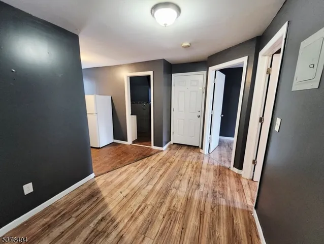 an empty room with wooden floor and entrance