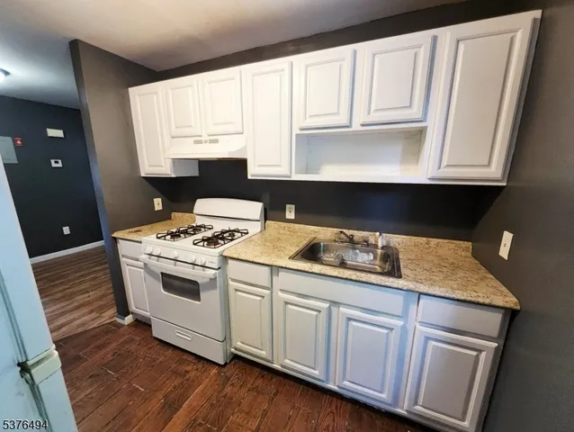 a kitchen with granite countertop white cabinets and white appliances
