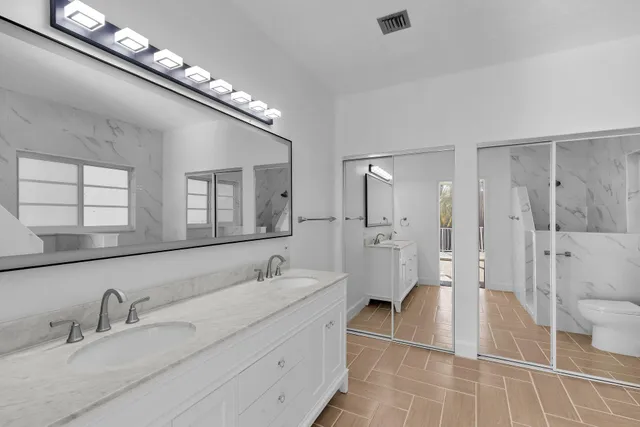 a bathroom with a sink toilet vanity and tub