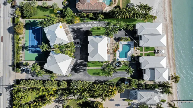 an aerial view of a city with lots of residential buildings and ocean view in back