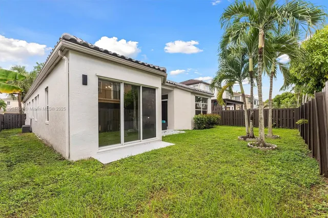 a view of a house with backyard and a tree