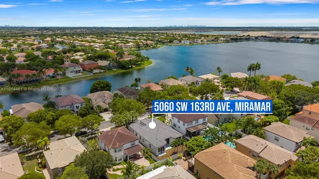 an aerial view of a house with outdoor space and lake view in back