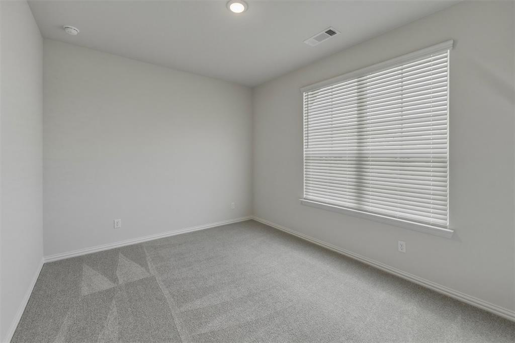 1325 Frio Drive Springtown, TX 76082 - Photo 11 of 24 Spacious room featuring neutral paint, gray patterned carpet, a large window with blinds, recessed lighting, and white baseboards