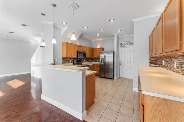 a kitchen with kitchen island granite countertop a stove top oven a sink and a refrigerator