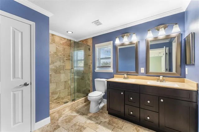 a bathroom with a double vanity sink toilet and shower
