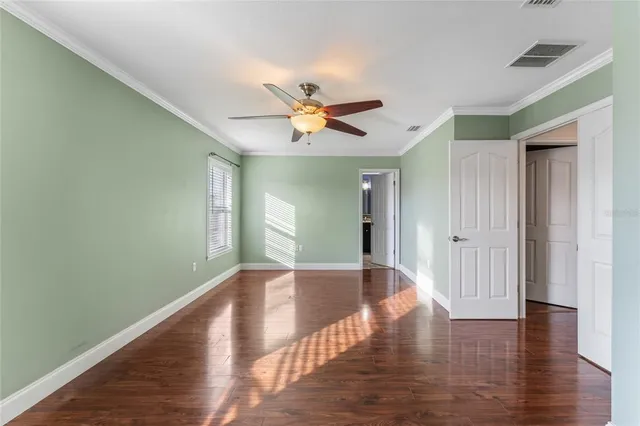 a view of an empty room with window and wooden floor
