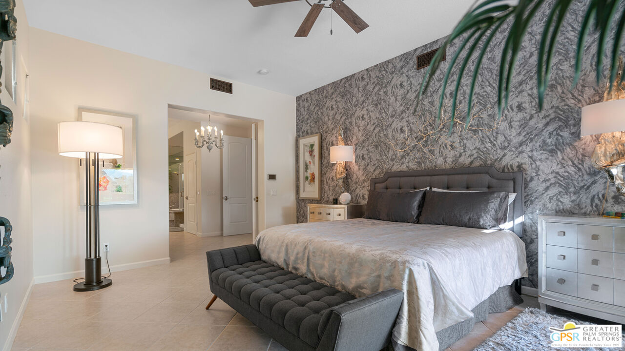 72 North Kavenish Drive Rancho Mirage, CA 92270 - Photo 23 of 73 a bedroom with a bed and a chandelier
