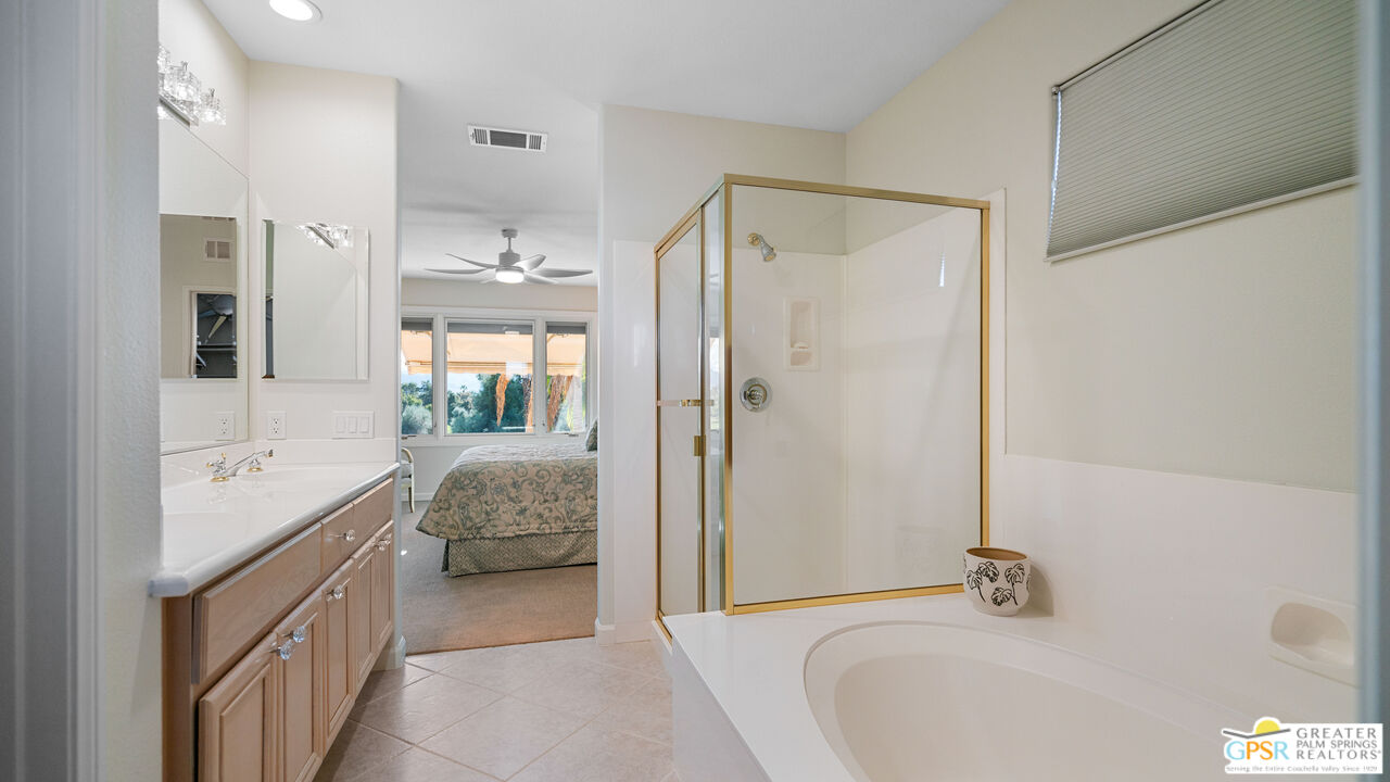 72 North Kavenish Drive Rancho Mirage, CA 92270 - Photo 38 of 73 a en suite bathroom with a granite countertop tub sink a mirror a shower and a bathtub