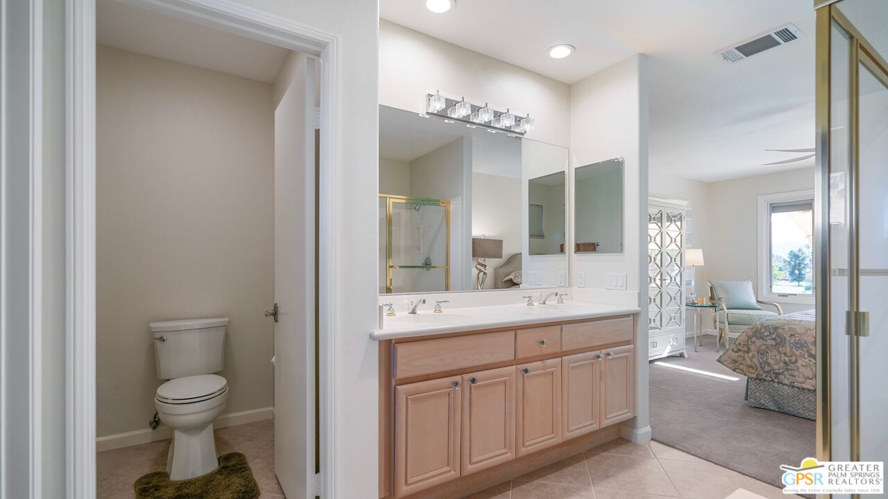 72 North Kavenish Drive Rancho Mirage, CA 92270 - Photo 39 of 73 a bathroom with a toilet a sink and a large mirror
