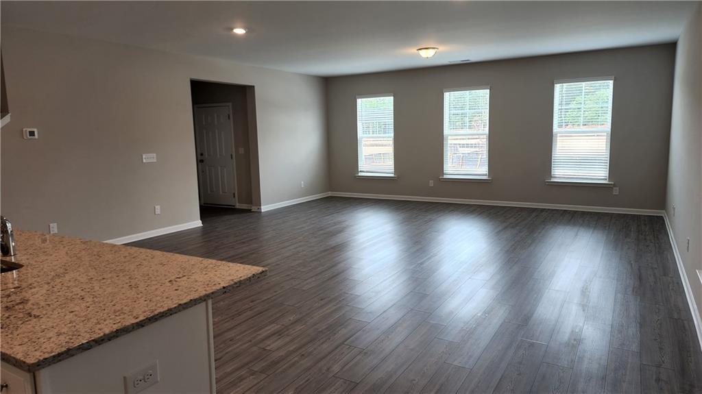 400 Grey Falcon Avenue Braselton, GA 30517 - Photo 13 of 31 an empty room with wooden floor and windows