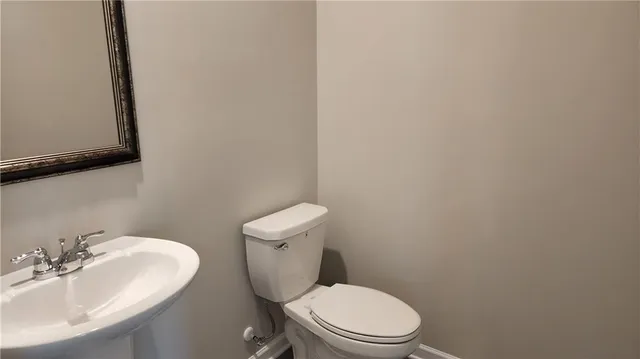 a white toilet sitting next to a bathroom sink