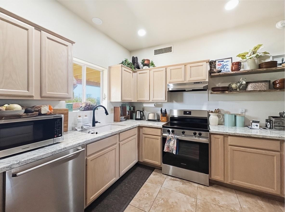 1033 East Irvine Road, Unit A Phoenix, AZ 85086 - Photo 7 of 26 a kitchen with stainless steel appliances granite countertop a sink and stove top oven