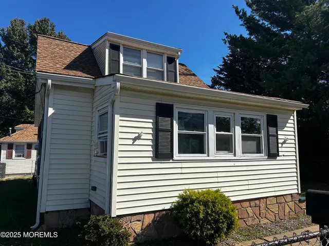 a view of a house with a yard and potted plants