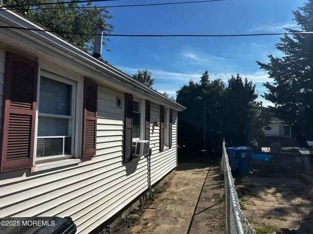 a white house with a large window and flower plants