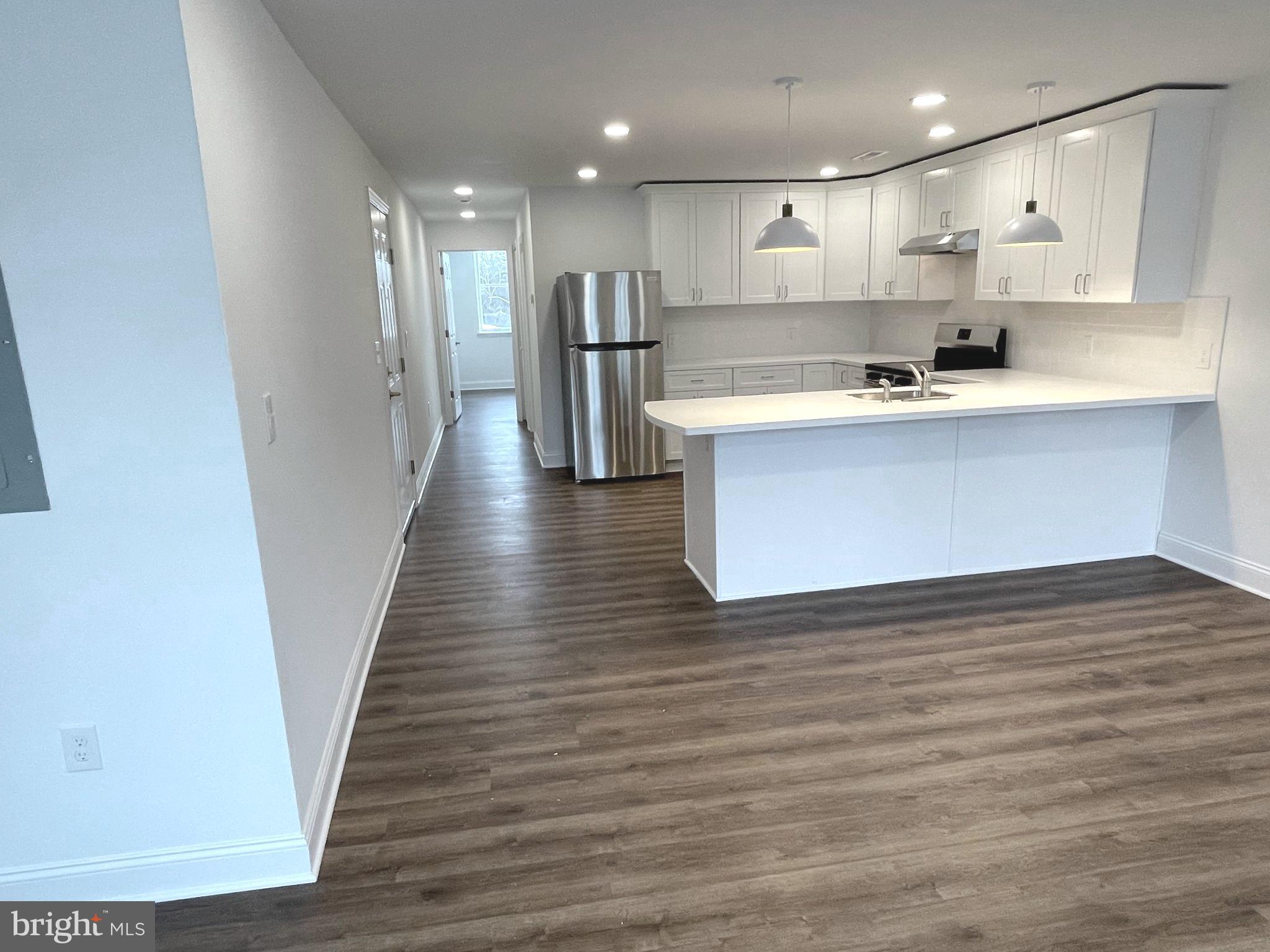 26 South State Street, Unit 2A Newtown, PA 18940 - Photo 7 of 18 Kitchen with Breakfast Bar into bed/bath hallway