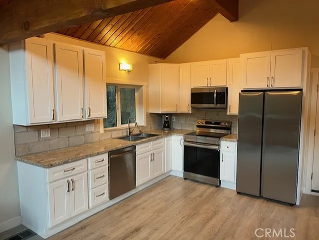 a bathroom with a granite countertop toilet a sink a mirror and a shower