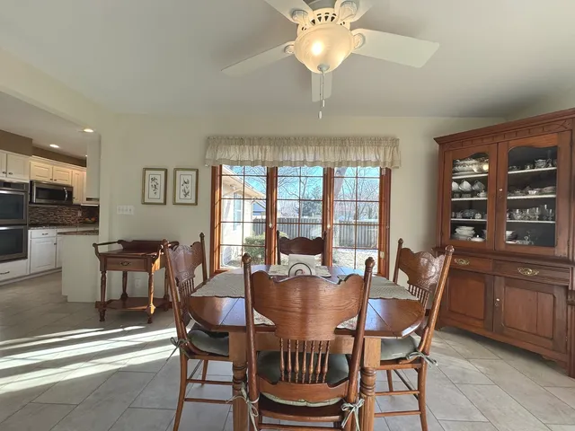 a dining room with furniture a chandelier and window