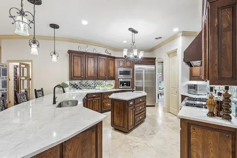 a kitchen with stainless steel appliances granite countertop a sink a stove and a refrigerator