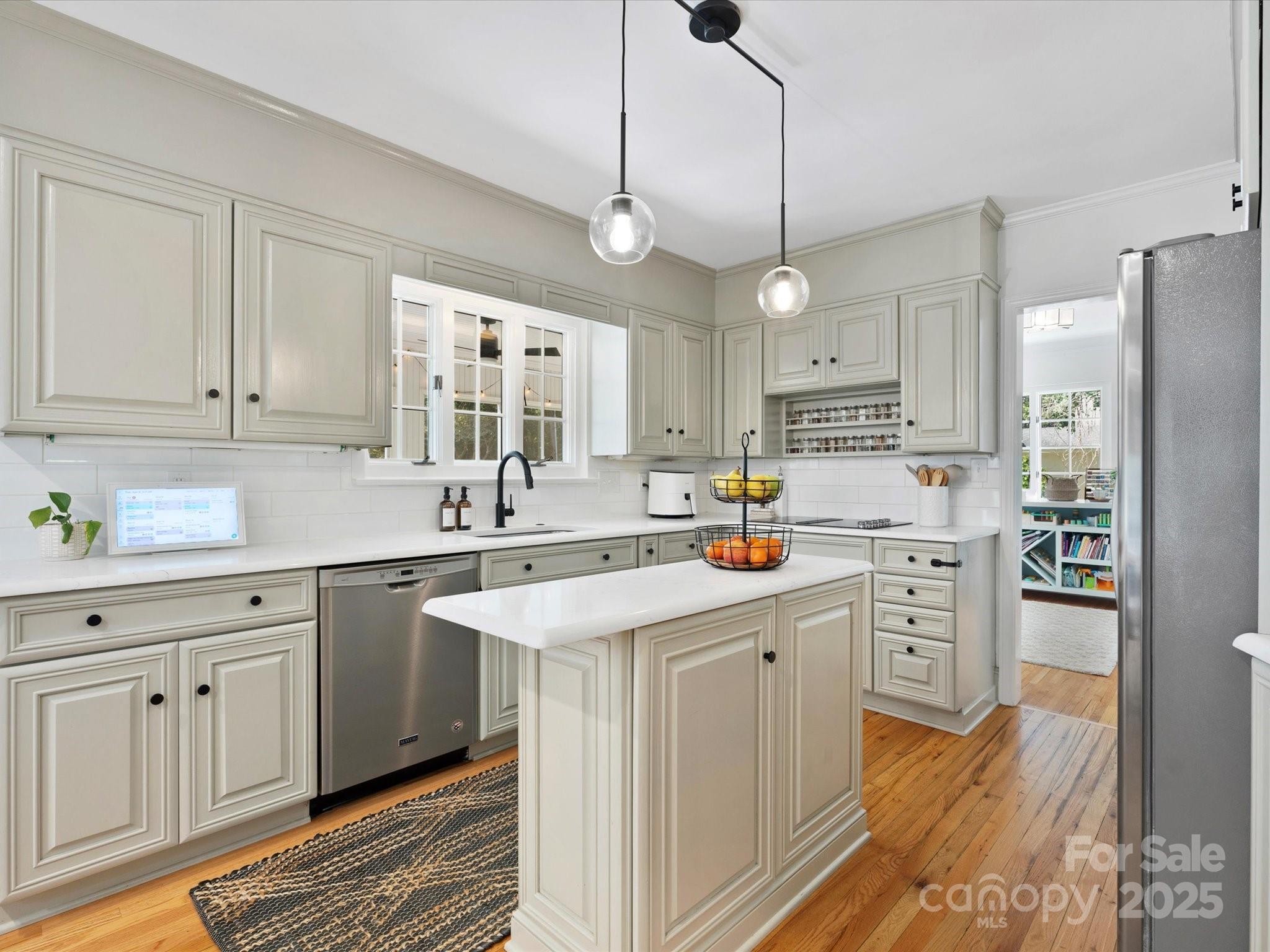 1927 South Wendover Road Charlotte, NC 28211 - Photo 3 of 36 a kitchen with stainless steel appliances granite countertop a refrigerator a sink dishwasher a stove and white cabinets with wooden floor