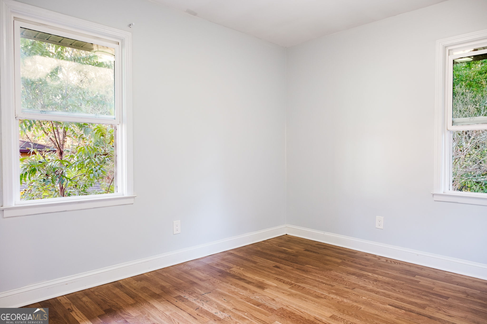 893 Slash Pine Road Forest Park, GA 30297 - Photo 22 of 38 an empty room with wooden floor and windows