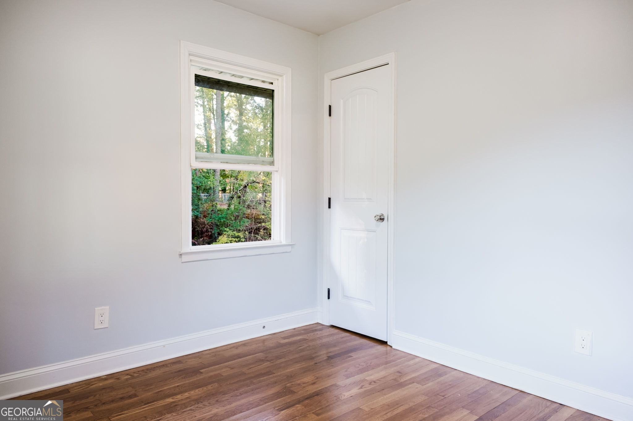 893 Slash Pine Road Forest Park, GA 30297 - Photo 24 of 38 an empty room with wooden floor and windows
