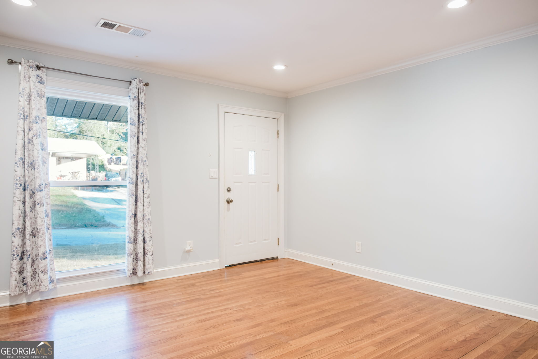 893 Slash Pine Road Forest Park, GA 30297 - Photo 5 of 38 a view of an empty room with wooden floor and a window