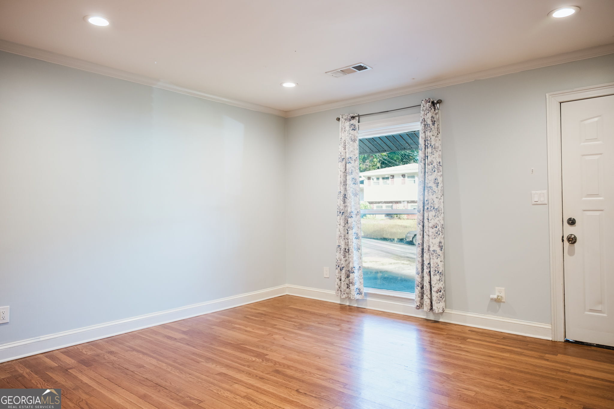 893 Slash Pine Road Forest Park, GA 30297 - Photo 6 of 38 a view of an empty room with wooden floor and a window