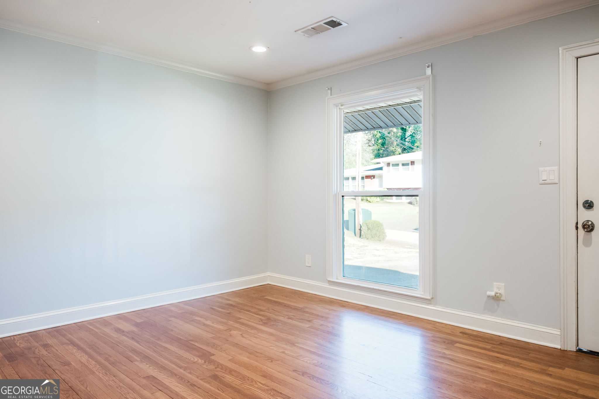 893 Slash Pine Road Forest Park, GA 30297 - Photo 7 of 38 an empty room with wooden floor and windows
