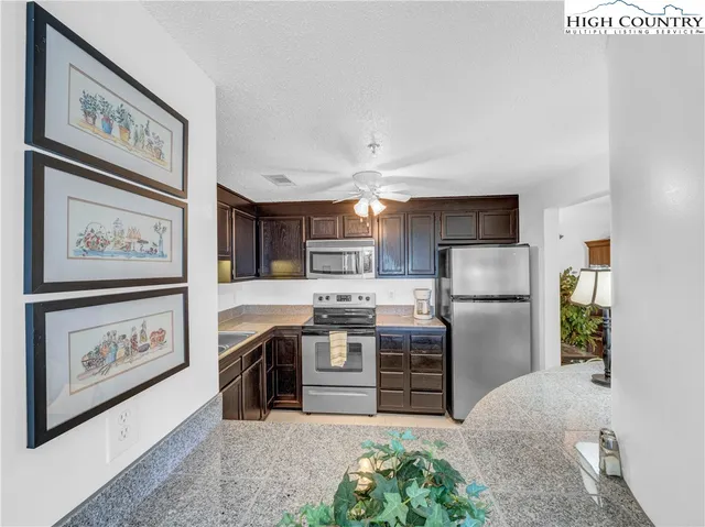 a kitchen with stainless steel appliances granite countertop a refrigerator and a stove