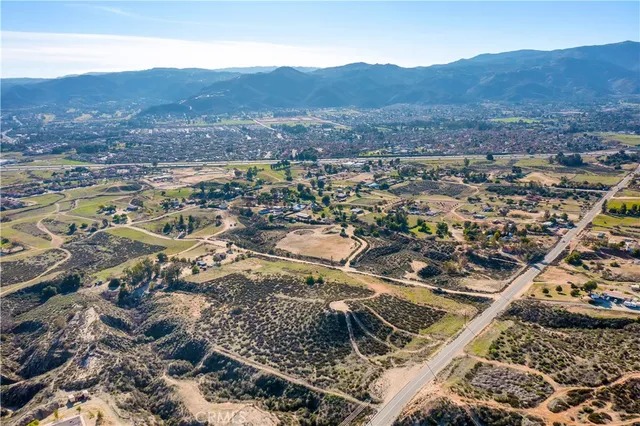 a view of a dry yard with mountains in the background