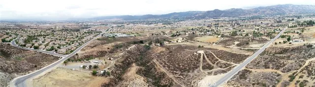 a view of a dry yard with wooden fence