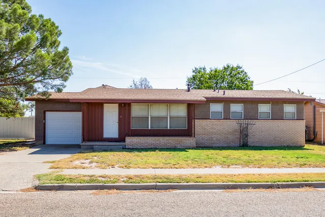 a front view of a house with a garden and yard