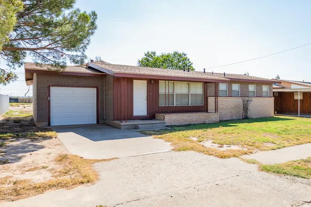 a view of a house with a yard and garage