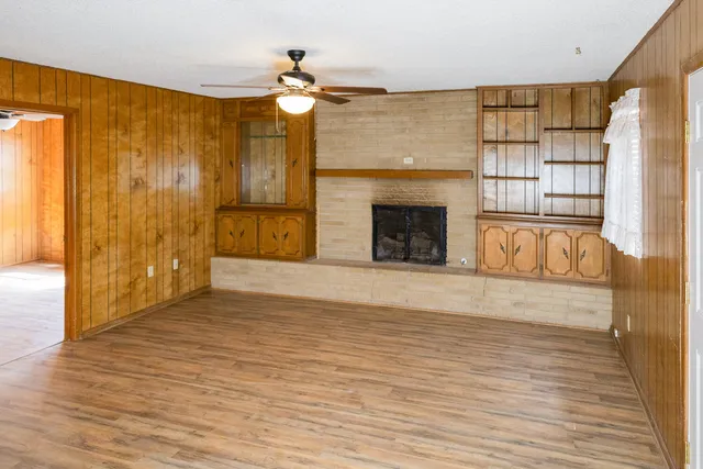 a view of an empty room with a fireplace and a window