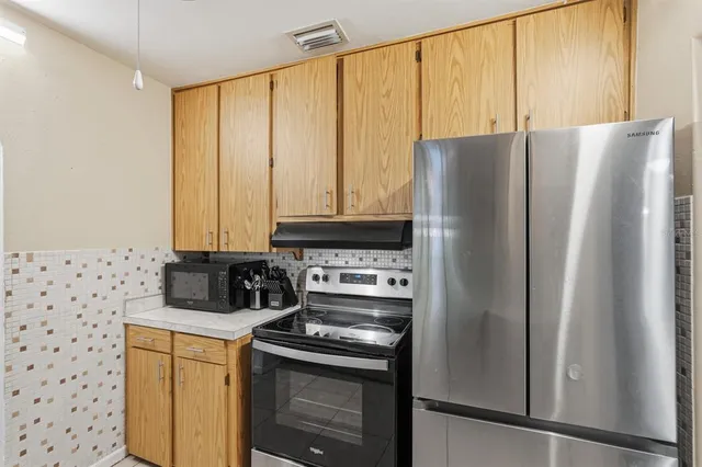 a kitchen with stainless steel appliances a refrigerator and a stove