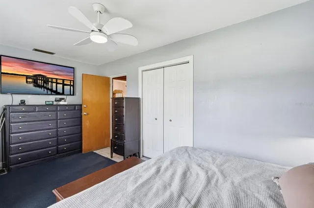 a view of a bedroom with closet cabinet closet and windows