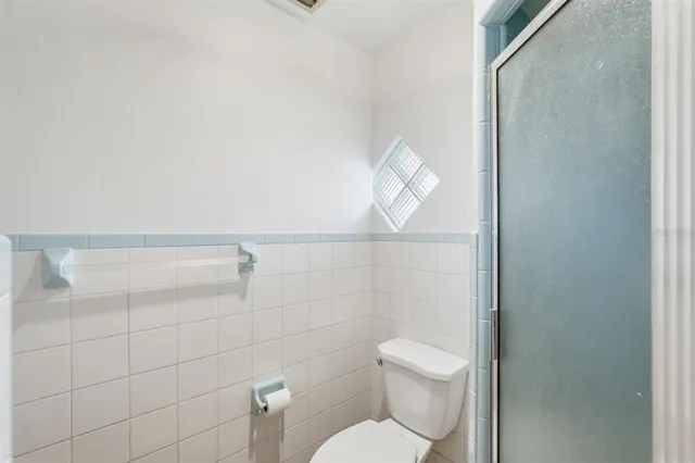 a bathroom with a toilet and a shower