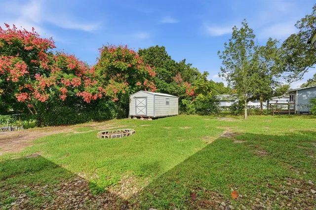 a sign that is sitting in the grass near a tree
