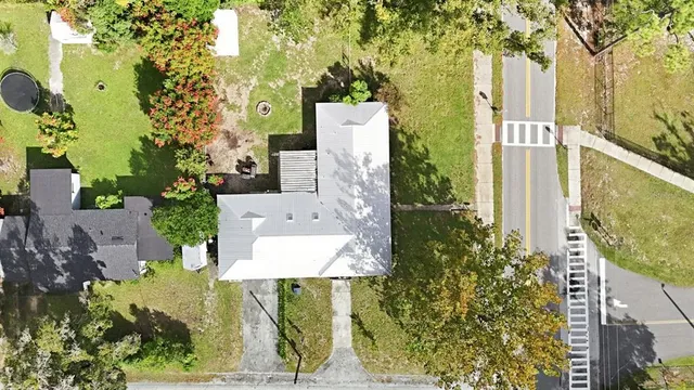 an aerial view of residential houses with outdoor space and trees