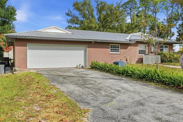 an aerial view of residential houses with outdoor space and trees