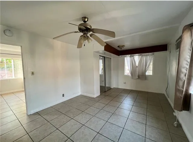 a view of a refrigerator in kitchen and an empty room