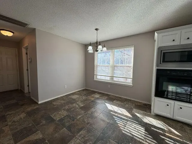 an empty room with closet and a chandelier fan